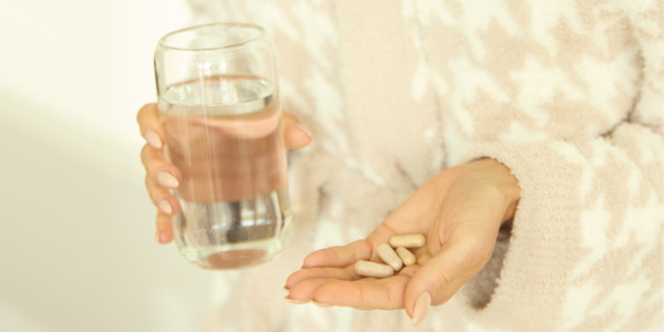 Close Up of Woman Holding Glass of Water and Pills | Belle Vitale